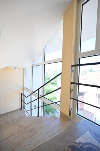 an empty room with a staircase and large windows at Smeštaj TEA sa dva bazena i besplatan parking in Vrnjačka Banja