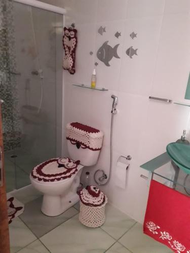 uma casa de banho com um WC e uma cabina de duche em vidro. em Casa de Temporada no Paraíso Guaraú em Peruíbe