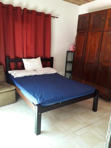 a bed in a room with a red curtain at Casa de Temporada no Paraíso Guaraú in Peruíbe