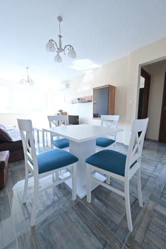 a dining room with a white table and chairs at Smeštaj TEA sa dva bazena i besplatan parking in Vrnjačka Banja