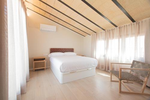 1 dormitorio con cama blanca y ventana en Casa Tai, en Tivenys