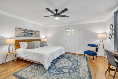 Un dormitorio blanco con una cama y una silla azul. en Haynesworth Manor, en Greenville