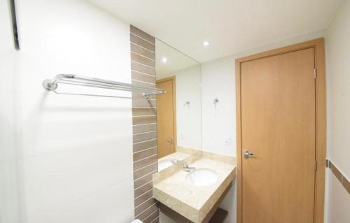a bathroom with a sink and a mirror at Hotel Park Veredas - Rio Quente Flat 225 in Rio Quente