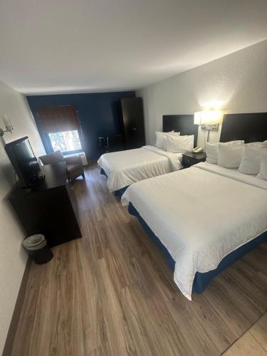 a hotel room with two beds and a television at Brandon Center Hotel in Tampa