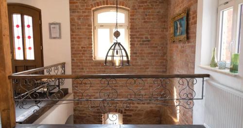 a staircase with a brick wall and a chandelier at Schuster Bude in Münchhausen