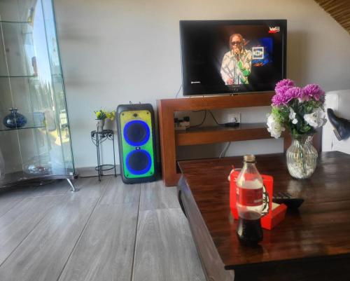 a living room with a tv and a table with at Sky view Guest House in Johannesburg