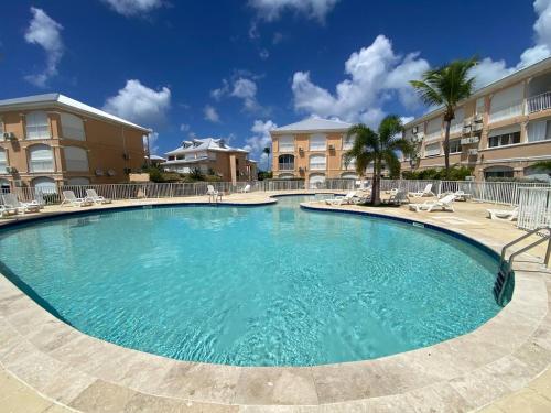 a large swimming pool with chairs and condos at Flamboyant Oasis in Baie Nettle