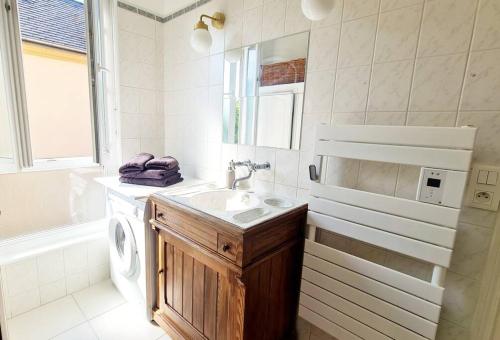 a bathroom with a sink and a washing machine at Unique et élégant, gare hyper centre wifi in Vernon