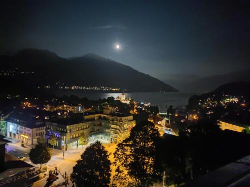 a view of a city at night with the moon at THE BEST LAKE HOUSE -3 minutes to the train in Spiez