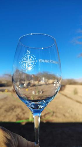 a person holding a wine glass with water in it at Cabañas Voyage Atacama in San Pedro de Atacama