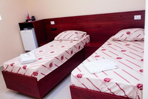 two twin beds in a room with at Hotel e Motel Madrugada in Itu