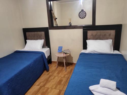 Habitación con 2 camas y espejo. en HOME BLESSED II, en Lima