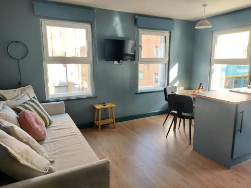 a living room with a couch and a table and windows at Cathedral Quarter Apartments in Derry Londonderry