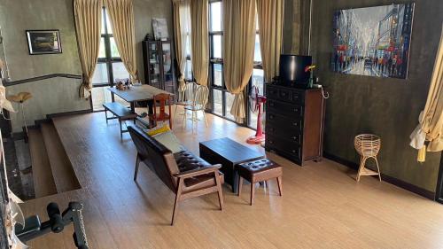 a living room with chairs and tables and a television at Modern Loft Style in Nakhon Phanom