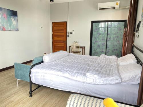 ein Schlafzimmer mit einem großen weißen Bett in einem Zimmer in der Unterkunft Modern Loft Style in Nakhon Phanom