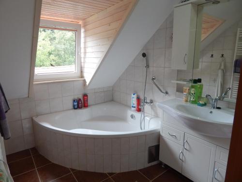 a bathroom with a large tub and a sink at Sunny Holiday House B&B in Ljubno