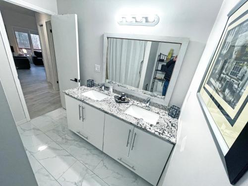 a bathroom with two sinks and a large mirror at Forest Retreat - Pool - Games - Fireside Joy in Cayuga