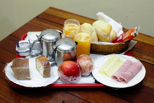 a tray of food with bread and fruit on a table at Hotel e Motel Madrugada in Itu