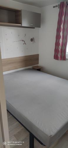 an empty bed in a room with a window at Domaine de karlann 4Etoiles Mobil-home in Pont-Aven