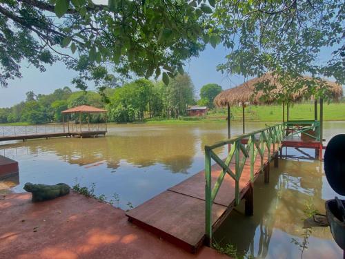 uma grande massa de água com uma doca e um edifício em Cabaña del lago em Ciudad del Este