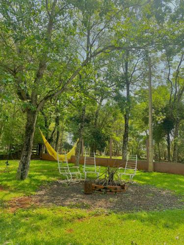 a playground with two chairs and a slide in a park at Cabaña del lago in Ciudad del Este