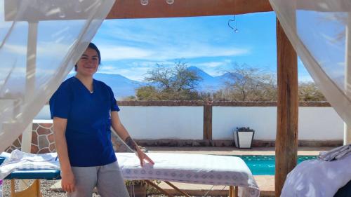 a woman standing in a room with a bed at Cabañas Voyage Atacama in San Pedro de Atacama