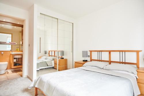 a bedroom with a large white bed and a bathroom at Apartment in old street in London