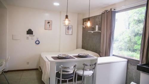 a small kitchen with a table and two chairs at STUDIO 301 | WIFI 600MB | RESIDENCIAL JC, um lugar para ficar. in Belém