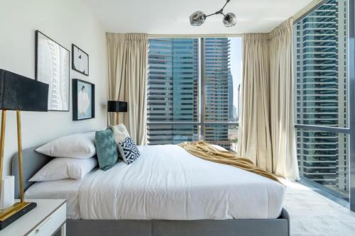 a bedroom with a large bed and a large window at Breathtaking Skyscrapers View in Dubai