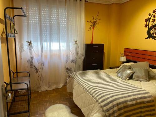1 dormitorio con 1 cama y una ventana con cortinas en Army Deluxe, en Astorga