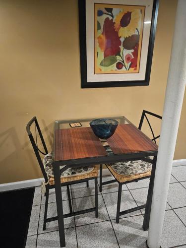 a dining room table with two chairs and a bowl on it at Cozy Queens Apartment 5 mins from LaGuardia and 1 min from train in Queens