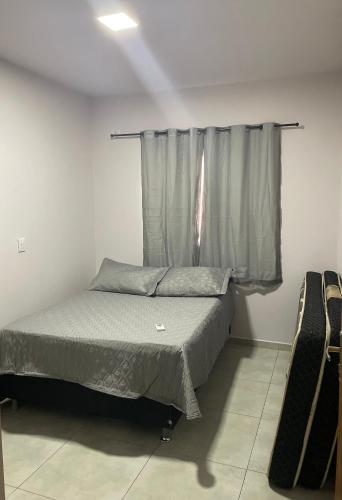 ein kleines Schlafzimmer mit einem Bett und einem Fenster in der Unterkunft Casa completa e espaçosa in Foz do Iguaçu
