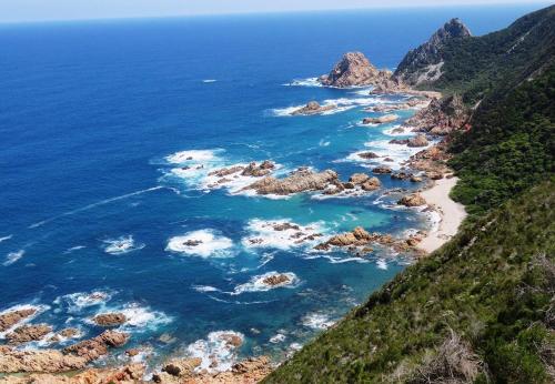 an aerial view of a beach with rocks and the ocean at Mount Castleton in Plettenberg Bay