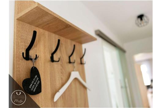 a wooden rack with hangers on a wall at Ferienwohnung MOTJE in Rastede in Rastede