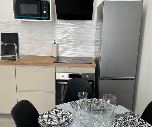une cuisine avec une table avec des chaises et un micro-ondes dans l'établissement Appartement de standing, à Marseille