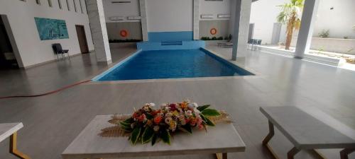 a bouquet of flowers on a table in front of a pool at غرف قاعة وشاليه ومسبح ماز in Al Rass