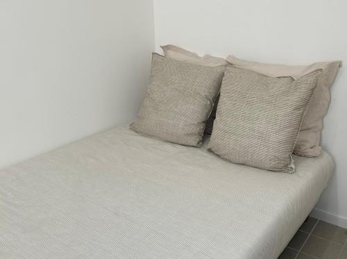 un lit avec quatre oreillers dessus dans l'établissement Appartement de standing, à Marseille