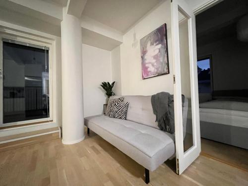 białą kanapę w pokoju z oknem w obiekcie modern apartment with private terrace w Helsinkach