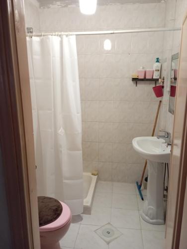 uma casa de banho com um WC cor-de-rosa e um lavatório. em شقة مفروشة مكيفة للايجار بجبل طارق 
