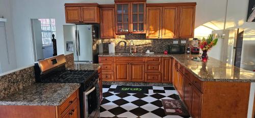 a kitchen with wooden cabinets and a checkered floor at Montecello Heights in Portsmouth