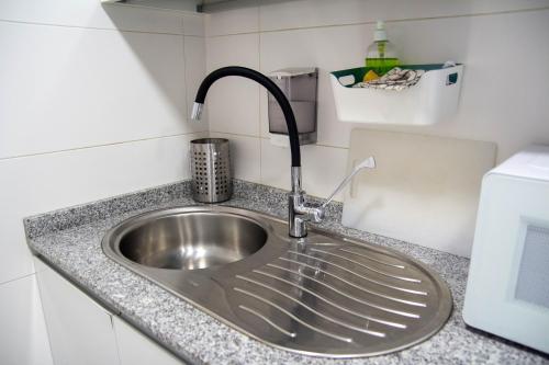 un fregadero de acero inoxidable en una pequeña cocina en Scout Madrid Hostel, en Madrid