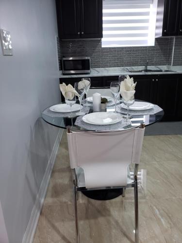 a table with two plates and glasses on it in a kitchen at Luxurious 1BR-1BA Apartment Bright Spacious with free parking-gc-1 in Brampton