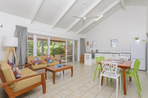 eine Küche und ein Wohnzimmer mit einem Tisch und Stühlen in der Unterkunft Rarotonga Daydreamer Escape in Rarotonga