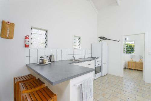 a white kitchen with a counter and a refrigerator at Rarotonga Daydreamer Escape in Rarotonga