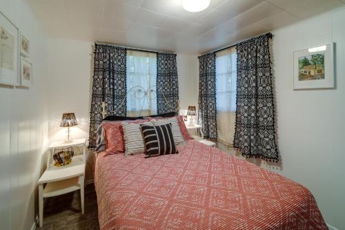 a bedroom with a bed with a red bedspread at Newport Cabin on Diamond Lake with Private Boat Dock in Newport