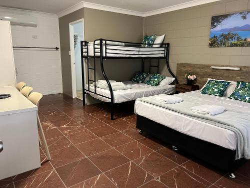 a room with two bunk beds and a kitchen at Spanish Lace Motor Inn in Townsville