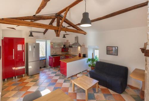 een woonkamer met een bank en een keuken bij Maisonnette Lotoise, meublé de tourisme 3 étoiles in Fargues