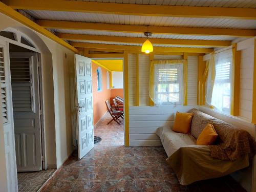 sala de estar con sofá y ventana en Maison d'une chambre avec vue sur la mer jardin clos et wifi a Le Diamant a 1 km de la plage, en Le Diamant