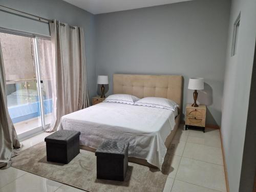 a bedroom with a bed and a large window at Aconchegante Refúgio Beira-Mar in Praia