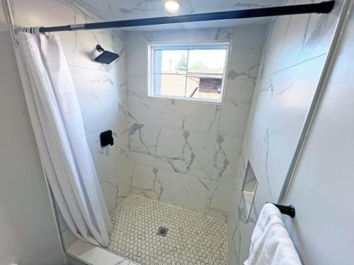 a bathroom with a shower with a window at Luxe Home Near Limeridge - Sleeps 11 - Pool in Hamilton